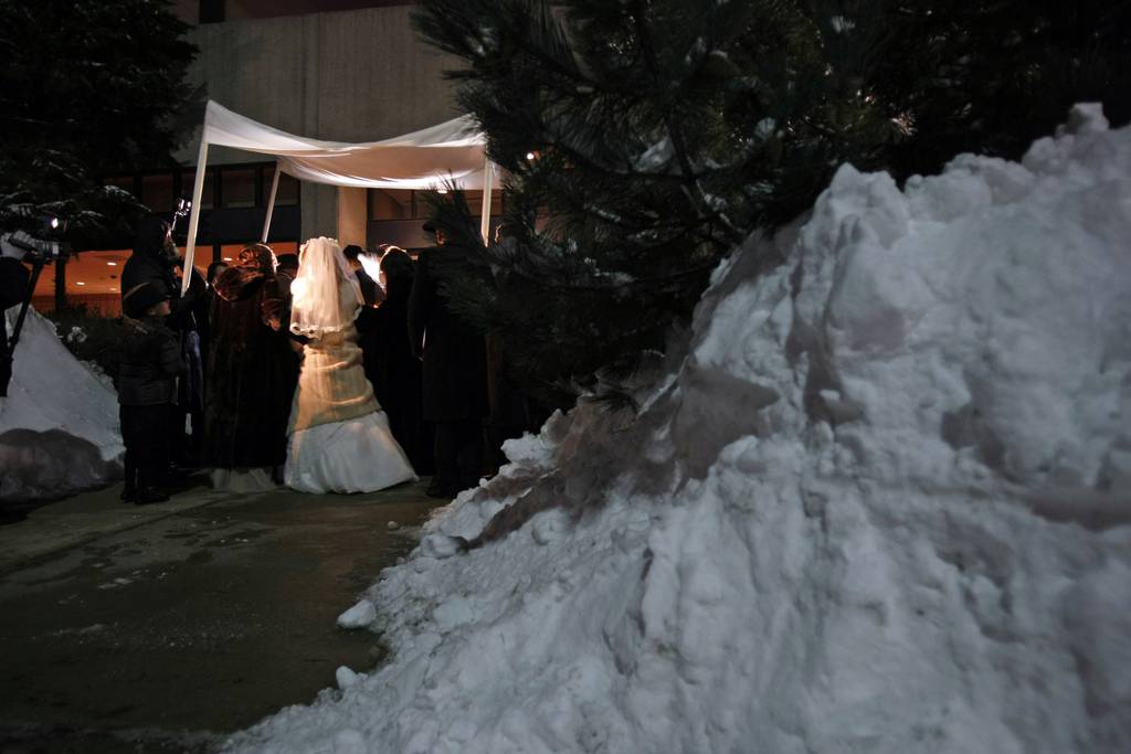 couple under chuppah prior to snow plowing